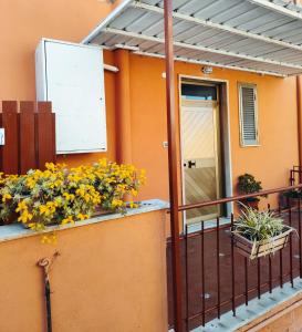 an orange house with flowers on a balcony at La casa di Lilly in Civitavecchia