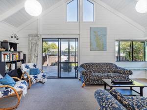 a living room with a couch and chairs at Beaumont Beach Retreat - Pauanui Holiday Home in Pauanui