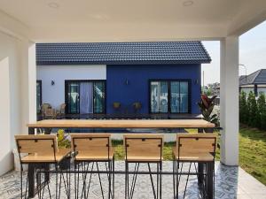 une maison avec une table et des chaises devant dans l'établissement Morning Glory Pool Villa Chaam-Huahin, à Sathani Huai Sai Tai