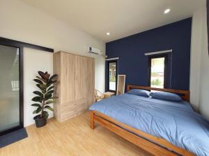 une chambre avec un mur bleu et un lit dans l'établissement Morning Glory Pool Villa Chaam-Huahin, à Sathani Huai Sai Tai 26 autres photos