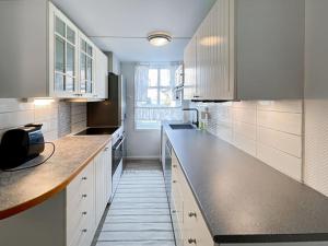 une cuisine avec des armoires blanches et un comptoir dans l'établissement Cozy Corner 1 By Stavanger Bnb, à Stavanger