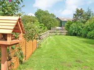 a backyard with a fence and a grass yard at The Bothy in Malvern Wells