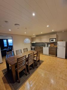 a kitchen and dining room with a wooden table and chairs at Sport Hotel Kantri in Kankaanpää