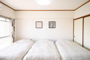 Una cama o camas en una habitación de Living CUBE Beppu Station ANX