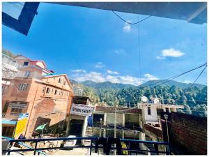 a view of a city with mountains in the background at DALHOUSIE HOTEL S A H A R A - Near Bus Stand - Hygiene & Spacious Room in Banikhet
