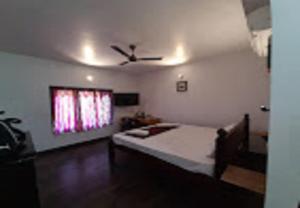 a bedroom with a bed and a ceiling fan at The French Villa Elite in Puducherry