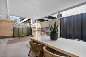 a table with chairs and a potted plant on it at Glenelg Hideaway Bliss in Glenelg +24 photos
