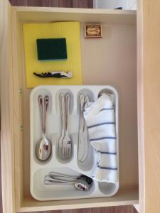 a drawer filled with utensils in a cabinet at Apartment historical city in Znojmo