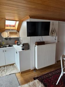 a kitchen with white cabinets and a flat screen tv at Kostis Central Loft in Metsovo +34 photos