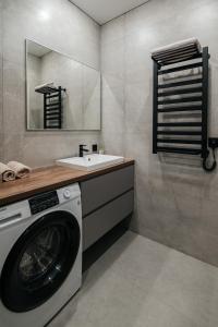 a bathroom with a washing machine and a sink at ЖК Sun city in Oral +17 photos