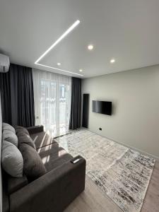 a living room with a couch and a flat screen tv at ЖК Sun city in Oral