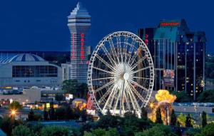 a large ferris wheel in a city at night at Adorable 2-bedroom unit with jacuzzi beside falls in Niagara Falls