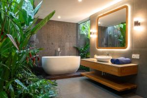 a bathroom with a large sink and a large mirror at Villa Suarga Des Anicca in Ubud