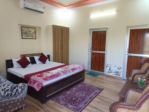 Un dormitorio con una cama y dos sillas. en Yuvraj Nature Resort, en Pushkar 69 fotos más