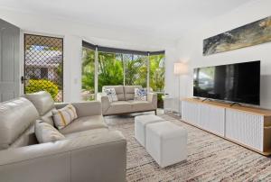 a living room with a large flat screen tv at 2 Bedroom Villa In Tropical Resort in Noosaville