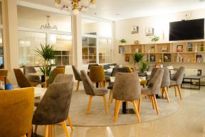 a restaurant with tables and chairs and a flat screen tv at Hotel Panonija in Sisak