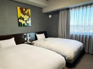 Postel nebo postele na pokoji v ubytování Hotel Route-Inn Iwata Inter