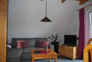 ein Wohnzimmer mit einer grauen Couch und einem Tisch in der Unterkunft Ferienwohnung für 2 Personen ca 35 m in Walkenried, Harz Unterharz - a82758 in Walkenried