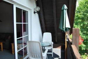 eine Terrasse mit einem Tisch, einem Sonnenschirm und Stühlen in der Unterkunft Ferienwohnung für 2 Personen ca 35 m in Walkenried, Harz Unterharz - a82758 in Walkenried