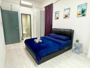 a bedroom with a bed with a blue comforter and a toilet at Sutera Avenue Homestay , Opposite Imago , Kota Kinabalu in Kota Kinabalu +11 photos