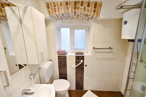 een badkamer met een toilet en een raam bij Apartment Aldora in Zadar +31 foto's