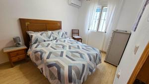 a bedroom with a bed with a comforter and a window at Villa Bonita in Mazarrón