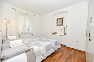 een witte slaapkamer met een bed en een raam bij Apartment Aldora in Zadar