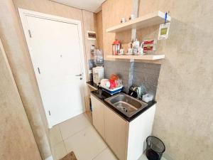 a small kitchen with a sink next to a door at Barsa City Babarsari 266 in Yogyakarta +4 photos