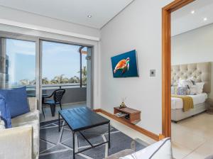 a living room with a couch and a bed and a table at Eden Palms , Ballito in Shakaʼs Rock +105 photos
