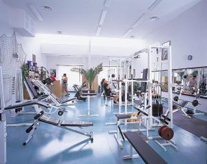 a gym with several tread machines and people in it at Sportovní Centrum Semily in Semily