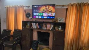 Una sala de estar con televisión y chimenea. en Samarpan, en Nainital