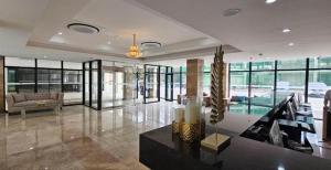 a large room with a lobby with a table and glass doors at The Glory Hotel in Mabalacat