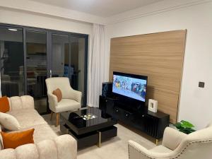 un salon avec un canapé et une télévision à écran plat dans l'établissement New Dawn Home, à Ruaka