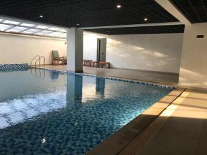 a large swimming pool with blue water in a building at New Dawn Home in Ruaka