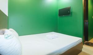 a small bedroom with a bed with a green wall at Ranchotel General Trias Cavite by RedDoorz in Uldugan