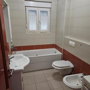 a bathroom with a tub and a toilet and a sink at Judita Apartments & Rooms in Međugorje +15 photos