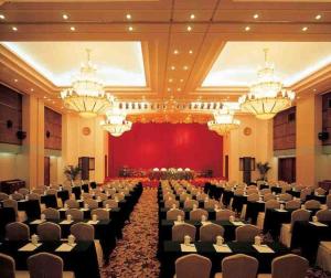 une grande salle de banquet avec des rangées de chaises et des lustres dans l'établissement New Century Hotel Ninghai, à Shang-ts'un