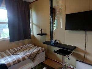 a bedroom with a bed and a desk and a television at Cozy room away from home in Åmot