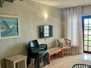 a living room with a table and chairs and a tv at Palms Beach Apartment- Seaviews in Port Alfred