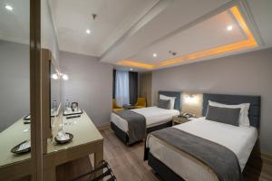 A bed or beds in a room at Amethyst Hotel