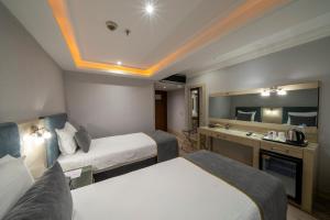 A bed or beds in a room at Amethyst Hotel