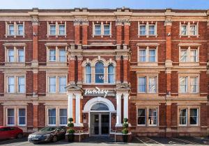 a large brick building with a sign on it at Exeter Rougemont Hotel by Sunday in Exeter
