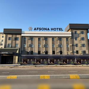 a hotel with a sign on the top of it at Afsona in Qarshi