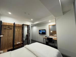 a bedroom with a bed and a desk and a television at Afsona in Qarshi