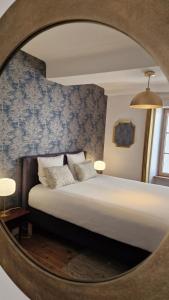 a bedroom with a bed with a mirror at La maison du Mont Saint Michel in Pontorson