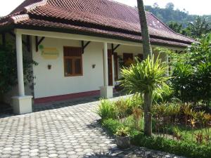 a small house with a tile roof at Guesthouse Rumah Senang in Kalibaru