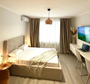 a bedroom with a bed and a desk with a computer at Monique's apartament 2 in Timişoara