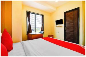 a bedroom with a bed with red pillows and a window at HOTEL SUPERIOR ELITE INN Best HOTEL IN KOLKATA in Belgachia +7 photos