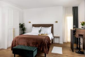a bedroom with a bed with a table and a piano at Olea Premium Rooms in Zadar