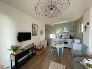 a living room with a table and a kitchen at L'étoile, Appartement 1 chambre, vue mer- rénové et cosy- tout inclus in Ault
